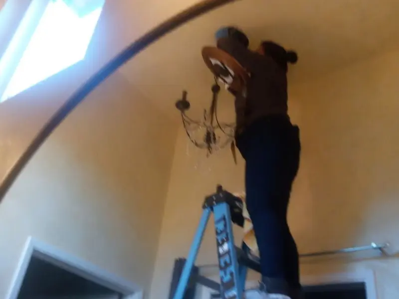 Electrician installing a chandelier in a Desert Hot Springs residence